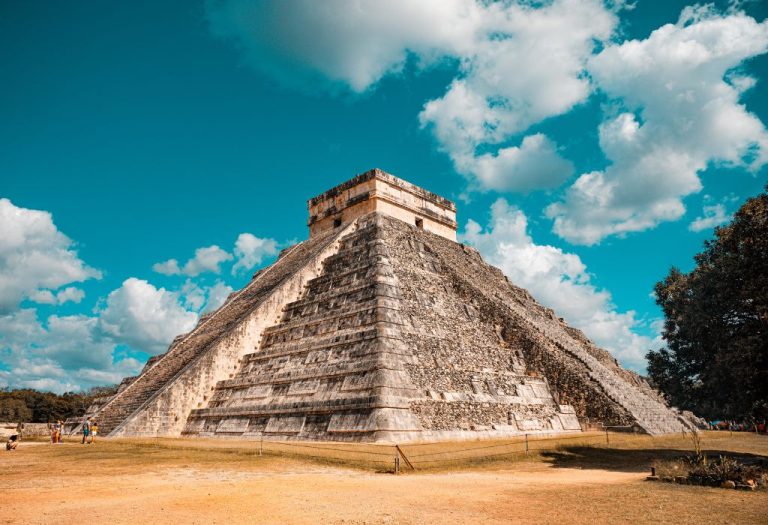 De indrukwekkende Tempel van Kukulcán in Chichén Itzá, Mexico, een van de nieuwe wereldwonderen, tegen een blauwe lucht met wolken.