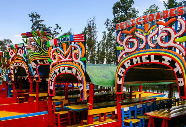 Traditionele, felgekleurde trajinera’s liggen aangemeerd in de kanalen van Xochimilco, een populaire toeristische attractie in Mexico-Stad.