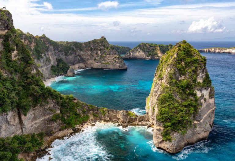 Spectaculaire kliffen en turquoise zee bij Nusa Penida, Bali, met rotsformaties en helderblauw water.